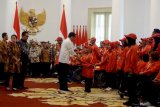 Presiden Joko Widodo (tengah) menyerahkan bonus prestasi kepada peraih perak dari cabang olahraga renang Asian Para Games 2018, Aris, sebagai perwakilan atlet, di Istana Kepresidenan Bogor, Jawa Barat, Sabtu (13/10). Presiden memberikan bonus uang kepada para atlet yang meraih medali dalam Asian Para Games 2018 karena dianggap telah mengharumkan nama bangsa di kancah internasional. ANTARA FOTO/Bayu Prasetyo/Ak/kye/18