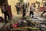 Personel kepolisian membersihkan puing bangunan dan kendaraan dinas yang dibakar oleh massa di Mapolsek Bendahara, Aceh Tamiang, Aceh, Rabu (24/10/2018). Aksi pembakaran gedung utama mapolsek, musala, tempat parkir, satu unit mobil patroli dan sepeda motor oleh massa yang terjadi pada Selasa (23/10/2018) dipicu tewasnya seorang tahanan kasus narkoba yang ditangani Polsek tersebut. ANTARA FOTO/Zamzami/wdy/2018