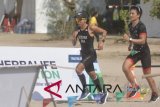 Atlet Triathlon Eva Desiana (kiri) dan pembalap Rio Haryanto (kanan) mengikuti Herbalife Bali International Triathlon 2018 di Sanur, Denpasar, Bali, Minggu (21/10/2018). Herbalife Bali International Triathlon 2018 diikuti 2.250 orang peserta dari berbagai negara, terbagi dalam tiga kategori utama yaitu, Olympic Distance Course (renang 1,5 km, sepeda 40 km, lari 10 km), Sprint Distance Course (renang 500m, sepeda 20 km, lari 5 km) dan 5 km Fun Run. ANTARA FOTO/Fikri Yusuf/wdy/2018