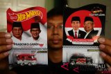 Perajin menunjukkan mobil mainan yang dimodifikasi bergambar pasangan calon presiden di desa Singocandi, Kudus, Jawa Tengah, Jumat (5/10/2018). Mobil mainan jenis 'Hot Wheels' yang diubah warna cat serta diberi gambar pasangan calon presiden Jokowi-Ma'ruf Amin dan Prabowo-Sandi tersebut dijual dengan harga Rp250.000 per buah dan dipasarkan melalui media sosial. ANTARA FOTO/Yusuf Nugroho/wdy/2018