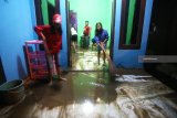 Warga membersihkan rumahnya yang terdampak banjir bandang di Desa Alas malang, Banyuwangi, Jawa Timur, Minggu (25/11/2018).  Warga di desa tersebut dihimbau agar tetap wasapada karena intensitas hujan yang tinggi dan diduga berpotensi banjir bandang susulan. Antara Jatim/Budi Candra Setya/ZK