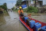 Petugas membawa BBM menggunakan perahu saat banjir melanda Andir, Kabupaten Bandung, Jawa Barat, Jumat (30/11/2018). Hujan lebat pada Kamis (29/11) yang mengguyur Bandung raya menyebabkan banjir setinggi 60 hingga 100 sentimeter akibat luapan Sungai Citarum. ANTARA JABAR/Raisan Al Farisi/agr.