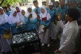 Petugas Badan Meteorologi Klimatologi dan Geofisika (BMKG) menerangkan cara kerja alat pengukur tingkat penguapan air dalam tanah pada siswa Madrasah Arrayadlah (MA) Paiton-Probolinggo di Stasioun BMKG Krangploso, Malang, Jawa Timur, Selasa (6/11/2018). Kegiatan pembelajaran luar kelas yang diikuti 65 siswa tersebut bertujuan mengenalkan hal-hal yang berkaitan dengan prakiraan cuaca, iklim serta perhitungan awal musim hujan. Antara Jatim/Ari Bowo Sucipto/ZK