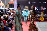 Model berjalan memperagakan busana batik di trotoar jalan Taman Blambangan , Banyuwangi, Jawa Timur, Jumat (16/11/2018). Peragaan busana batik di trotoar jalan tersebut, selain untuk mempromosikan batik Banyuwangi juga mengembalikan fungsi trotoar untuk pejalan kaki. Antara Jatim/Budi Candra Setya/ZK