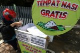 Warga memasukkan air minum ke dalam gerobak tempak makanan gratis yang disediakan komunitas motor 'Anak Soleh' di Kota Kediri, Jawa Timur, Jumat (9/11/2018). Gerobak sedekah tersebut memfasilitasi bagi siapapun untuk menaruh atau mengambil makanan minuman secara gratis. Antara Jatim/Prasetia Fauzani/ZK.