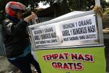 Warga memasukkan air minum ke dalam gerobak tempak makanan gratis yang disediakan komunitas motor 'Anak Soleh' di Kota Kediri, Jawa Timur, Jumat (9/11/2018). Gerobak sedekah tersebut memfasilitasi bagi siapapun untuk menaruh atau mengambil makanan minuman secara gratis. Antara Jatim/Prasetia Fauzani/ZK.