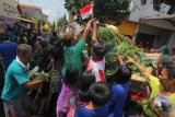 Warga berebut gunungan saat Grebeg Maulud di Jalan Kenjeran, Surabaya, Jawa Timur, Selasa (20/11/2018). Pawai yang diikuti ratusan warga Surabaya tersebut untuk memperingati hari lahir Nabi Muhammad SAW. Antara Jatim/Didik Suhartono/ZK