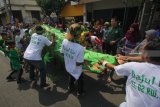 Warga berebut gunungan saat Grebeg Maulud di Jalan Kenjeran, Surabaya, Jawa Timur, Selasa (20/11/2018). Pawai yang diikuti ratusan warga Surabaya tersebut untuk memperingati hari lahir Nabi Muhammad SAW. Antara Jatim/Didik Suhartono/ZK