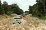 Sejumlah mobil melewati jalan yang berbatasan dengan Malaysia di Kecamatan Sekayam, Kabupaten Sanggau, Kalimantan Barat, Kamis (15/11/2018). Kementerian Pekerjaan Umum dan Perumahan Rakyat (PUPR) menargetkan dapat menyelesaikan pembangunan jalan perbatasan di wilayah Kalbar sepanjang 275,18 kilometer pada 2018, dengan alokasi anggaran sebesar Rp510 Miliar. ANTARA FOTO/HS putra/jhw



