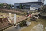 Warga melintasi jembatan yang rusak di Rancasari, Bandung, Jawa Barat, Minggu (25/11/2018). Jembatan yang rusak akibat diterjang banjir dari Sungai Cidurian pada Kamis (22/11) tersebut akan diperbaiki pada awal 2019. ANTARA FOTO/Raisan Al Farisi/aww.