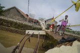 Warga melintasi jembatan yang rusak di Rancasari, Bandung, Jawa Barat, Minggu (25/11/2018). Jembatan yang rusak akibat diterjang banjir dari Sungai Cidurian pada Kamis (22/11) tersebut akan diperbaiki pada awal 2019. ANTARA FOTO/Raisan Al Farisi/aww.