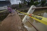 Warga melintasi jembatan yang rusak di Rancasari, Bandung, Jawa Barat, Minggu (25/11/2018). Jembatan yang rusak akibat diterjang banjir dari Sungai Cidurian pada Kamis (22/11) tersebut akan diperbaiki pada awal 2019. ANTARA FOTO/Raisan Al Farisi/aww.