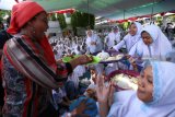 Menteri Kelautan dan Perikanan Susi Pudjiastuti (kiri) membagikan lauk ikan kepada santriwati di Pondok Pesantren Darussalam Blokagung, Banyuwangi, Jawa Timur, Sabtu (3/11/2018). Kunjungan kerja menteri susi ke Pondok Pesantren itu, untuk mengkampanyekan Gemarikan (Gerakan memasyarakatkan makan ikan) bersama 8ribu santri. ANTARA FOTO/budi Candra Setya. Antara Jatim/Budi Candra Setya/ZK