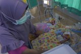 Petugas merawat dua dari tiga bayi kembar yang lahir prematur dengan bobot di bawah normal di ruang Neonatal Intensif care Unit (NICU) RSUD dr Iskak, Tulungagung, Jawa Timur, Kamis (8/11). Bayi kembar tiga hasil inseminasi buatan (in vitro fertilisation) tersebut lahir pada Rabu (7/11) pagi sekitar pukul 09.23 - 09.25 WIB melalui tindakan operasi bedah cecar di RSUD dr Iskak, dengan bobot masing-masing 1,710 gram, 1.440 gram, dan 1.810 gram. Antara Jatim/Destyan Sujarwoko/ZK.