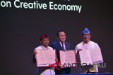 Kepala Badan Ekonomi Kreatif Triawan Munaf (tengah) bersama Gubernur Jawa Barat Ridwan Kamil (kanan) dan Gubernur Bali I Wayan Koster memperlihatkan naskah nota kesepahaman (MoU) pada pembukaan Konferensi Internasional Ekonomi Kreatif (WCCE) di Nusa Dua, Bali, Rabu (7/11/2018). Nota kesepahaman tersebut merupakan dasar kerja sama Badan Ekonomi Kreatif dengan pemerintah daerah dalam pengembangan ekonomi kreatif. Antara Foto/Nyoman Budhiana.