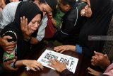 Lutfinani Eka Putri (kiri) istri dari Deryl Fida Febrianto korban dari Lion Air JT-610 menangis diatas peti jenazah ketika tiba di rumah duka Jalan Simo Pomahan Baru, Surabaya, Jawa Timur, Selasa (13/11/2018). Tim Disaster Victim Identivication (DVI) hingga saat ini sudah mengidentifikasi 82 orang penumpang dari 189 orang penumpang korban Lion Air JT-610. Antara Jatim/M Risyal Hidayat/ZK