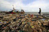 Nelayan menyandarkan perahunya di bibir pantai yang dipenuhi sampah plastik di Desa Dadap, Indramayu, Jawa Barat, Senin (26/11/2018). LSM World Wild Fund for Nature (WWF) Indonesia menilai masalah pencemaran sampah plastik di laut Indonesia sudah bisa disebut sebagai darurat sampah plastik karena perlu penanganan serius. ANTARA JABAR/Dedhez Anggara/agr.