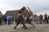 Dua pria memainkan olahraga Behampas saat acara Dahau di Taman Budaya Sendawar, Kabupaten Kutai Barat, Kalimantan Timur, Selasa (30/10/2018). Behampas yang merupakan olahraga tradisional khas Suku Dayak Tunjung dan Suku Dayak Benuaq, Kaltim tersebut, dimainkan oleh dua petarung yang saling memukul menggunakan sebilah rotan ke bagian belakang tubuh lawan. ANTARA FOTO/Sugeng Hendratno/jhw