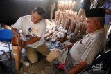 Petugas memasangkan kaki palsu kepada penderita disabilitas di kantor Dinas Sosial, Banda Aceh, Rabu (14/11/2018). Sebanyak 100 orang penderita disabilitas dari sejumlah kabupaten/kota di daerah itu mendapat bantuan kaki palsu dari Pemerintah Aceh setelah bantuan yang sama juga diberikan kaki palsu kepada 72 penderira disabilitas bantuan dari PT Angkasa Pura II pada Februari tahun 2018. (Antara Aceh/Ampelsa)