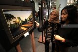 Pengunjung mengamati karya foto yang dipajang saat pameran fotografi bertajuk Napak Tilas Sejarah Surabaya di Surabaya, Jawa Timur, Rabu (21/11/2018). Pameran yang berlangsung hingga 23 November 2018 tersebut menampilkan karya-karya foto tempat bersejarah dan bangunan cagar budaya di Surabaya sekaligus merupakan rangkaian kegiatan memperingati Hari Pahlawan. Antara Jatim/Moch Asim/ZK