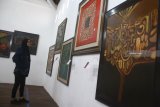 Pengunjung melihat lukisan kaligrafi karya pelukis Muhammad Sattar di Galery MHMS di Malang, Jawa Timur, Selasa (20/11/2018). Pameran yang digelar selama 30 hari tersebut diadakan untuk memperingati Maulud Nabi Muhammad. Antara Jatim/Ari Bowo Sucipto/ZK