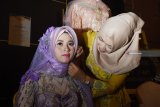 Penata rias merapikan riasan seorang model sebelum memeragakan busana saat pameran pernikahan yang dikemas dalam ‘Manigficent Wedding Exhibition 2018’ di Hotel Aston Madiun, Jawa Timur, Sabtu (17/11/2018) malam. Pegelaran busana tersebut diharapkan dapat menngkatkan kreatifitas para desainer khususnya dalam busana pernikahan. Antara Jatim/Siswowidodo/ZK