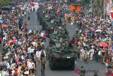 Warga menyaksikan barisan panser Anoa saat Parade Surabaya Juang di Surabaya, Jawa Timur, Minggu (11/11/2018). Parade yang diikuti ribuan peserta itu untuk memperingati Hari Pahlawan. ANTARA FOTO/Didik Suhartono/pras.