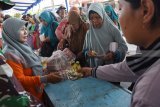 Warga antre membeli bahan pokok bersubsidi saat digelar pasar murah di Kabupaten Madiun, Jawa Timur, Jumat (16/11/2018). Pasar murah dalam rangka Hari Juang Kartika yang digelar Korem 081/Dhirotsaha Jaya, Kodim Madiun dan Pemkab Madiun tersebut menyediakan sejumlah bahan pokok bersubsidi, seperti beras harga di pasar Rp11.000 per kilogram dijual Rp6.500, minyak goreng Rp13.500 per kilogram dijual Rp10.000 dan gula pasir Rp11.000 per kilogram dijual Rp9.000. Antara Jatim/Siswowidodo/ZK