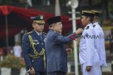 Wakil Presiden Jusuf Kalla (kedua kiri) menyematkan lencana pada perwakilan muda praja saat pelantikan muda praja angkatan XXIX di Kampus Institut Pemerintahan Dalam Negeri (IPDN), Kabupaten Sumedang, Jawa Barat, Jumat (2/11/2018). Wakil Presiden Jusuf Kalla melantik 1.994 orang calon muda praja menjadi muda praja IPDN untuk selanjutnya menempuh pendidikan selama empat tahun guna mempersiapkan muda praja menjadi aparatur pemerintahan. ANTARA JABAR/Raisan Al Farisi/agr.