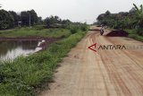 Warga berkendaraan melintas di Proyek pembangunan jalan Bojong Gede-Kemang (Bomang) yang mangkrak di Bojong Gede, Bogor, Jawa Barat, Senin (12/11/2018). Proyek pembangunan jalan senilai Rp. 67,9 miliar yang menghubungkan Cibinong-Bojong Gede-Tajurhalang, Kemang dan Parung tersebut mangkrak terkendala oleh pembebasan lahan warga. ANTARA JABAR/Yulius Satria Wijaya/agr.