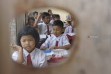 Siswa mengikuti kegiatan belajar-mengajar di ruang kelas darurat bekas parkir sepeda di SDN 03 Serut, Tulungagung, Jawa Timur, Senin (5/11). Pembelajaran di ruang kelas darurat semipermanen itu terpaksa dilakukan sejak enam tahun terakhir karena sekolah tersebut kekurangan satu unit ruang kelas untuk siswa kelas 2, sementara pengajuan anggaran pembangunan ke dinas pendidikan setempat belum kunjung dipenuhi. Antara Jatim/Destyan Sujarwoko/ZK.