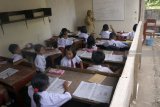 Siswa mengikuti kegiatan belajar-mengajar di ruang kelas darurat bekas parkir sepeda di SDN 03 Serut, Tulungagung, Jawa Timur, Senin (5/11). Pembelajaran di ruang kelas darurat semipermanen itu terpaksa dilakukan sejak enam tahun terakhir karena sekolah tersebut kekurangan satu unit ruang kelas untuk siswa kelas 2, sementara pengajuan anggaran pembangunan ke dinas pendidikan setempat belum kunjung dipenuhi. Antara Jatim/Destyan Sujarwoko/ZK.