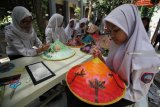 Murid-murid kelas 7 dan 8 SMP Negeri 19 Surabaya melukis caping dengan motif bunga dan alam saat memperingati Hari Cinta Puspa dan Satwa Nasional di Surabaya, Jawa Timur, Senin (5/11/2018). Kegiatan tersebut bertujuan untuk menanamkan kecintaan pelajar terhadap puspa atau tanaman dan satwa sekaligus mengajak masyarakat untuk turut serta melestarikan lingkungan. Antara Jatim/Moch Asim/ZK.