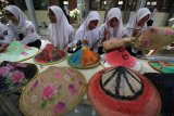 Murid-murid kelas 7 dan 8 SMP Negeri 19 Surabaya melukis caping dengan motif bunga dan alam saat memperingati Hari Cinta Puspa dan Satwa Nasional di Surabaya, Jawa Timur, Senin (5/11/2018). Kegiatan tersebut bertujuan untuk menanamkan kecintaan pelajar terhadap puspa atau tanaman dan satwa sekaligus mengajak masyarakat untuk turut serta melestarikan lingkungan. Antara Jatim/Moch Asim/ZK.