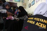 Kader pos pelayanan terpadu (posyandu) dibantu petugas kesehatan Puskesmas Ulee Kareng memberikan imunisasi pada balita di Lamteh, Banda Aceh, Aceh, Kamis (8/11/2018). Kementerian Kesehatan berharap kader Posyandu diseluruh nusantara menjadi garda terdepan pencegahan stunting yang telah menjadi ancaman pembangunan ekonomi dan kesejahteraan nasional. (Antara Aceh/Irwansyah Putra)