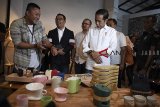 Calon Presiden Nomor Urut 01 Joko Widodo (kanan) didampingi Gubernur Jawa Barat Ridwan Kamil (kedua kiri) mencoba memakai jam yang dipamerkan sebelum berdiskusi dengan masyarakat kreatif Bandung di Simpul Space, Bandung, Jawa Barat, Sabtu (10/11/2018). Selain meninjau produk kreatif, Capres Joko Widodo juga berdialog dengan masyarakat kreatif Bandung dalam upaya mengembangkan ekonomi digital. ANTARA JABAR/Wahyu Putro A/agr.