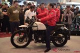 Presiden Joko Widodo (tengah) mencoba motor Royal Enfield saat mengunjungi Indonesia Motorcycle Show (IMOS) 2018 di Jakarta Convention Center, Jakarta, Sabtu (3/11/2018). Presiden mengunjungi IMOS 2018 untuk melihat perkembangan kemajuan industri sepeda motor Indonesia. ANTARA FOTO/Puspa Perwitasari/hp.