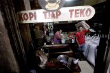 Pedagang membawa pesanan biji kopi yang dijual di Kedai kopi Tjap Teko Bogor, Jawa Barat, Rabu (21/11/2018). Menurut Asosiasi Eksportir dan Industri Kopi Indonesia (AEKI) Produksi kopi nasional tahun 2018 diperkirakan mencapai 11- 11,50 juta karung atau setara 660-690 ribu ton biji kopi. Angka itu meningkat dari produksi 2017 yang sekitar 560 ribu ton atau 9 juta karung. ANTARA JABAR/Yulius Satria Wijaya/agr.
