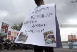 Sugiyanto (58) melakukan aksi jalan kaki dari Kota Tulungagung menuju Kota Kediri sejauh 35 kilometer sambil mengalungi poster di jalan raya Tulungagung, Tulungagung, Jawa Timur, Selasa (6/11/2018). Aksi solo itu dilakukan Sugiyanto sebagai bentuk protes atas kasus malpraktek penyuntikan vaksin MR (Measles and Rubella) terhadap anaknya, Wildan (12), yang mengalami kelumpuhan kaki total pascaimunisasi pada 23 Oktober 2018 di MTS Lirboyo, Kediri. Antara Jatim/Destyan Sujarwoko/ZK