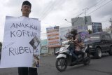 Sugiyanto (58) melakukan aksi jalan kaki dari Kota Tulungagung menuju Kota Kediri sejauh 35 kilometer sambil mengalungi poster di jalan raya Tulungagung, Tulungagung, Jawa Timur, Selasa (6/11/2018). Aksi solo itu dilakukan Sugiyanto sebagai bentuk protes atas kasus malpraktek penyuntikan vaksin MR (Measles and Rubella) terhadap anaknya, Wildan (12), yang mengalami kelumpuhan kaki total pascaimunisasi pada 23 Oktober 2018 di MTS Lirboyo, Kediri. Antara Jatim/Destyan Sujarwoko/ZK