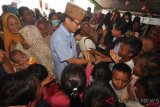     Calon Wakil Presiden nomor urut 02, Sandiaga Salahudin Uno menyapa anak-anak saat berkunjung ke lokasi pengungsian korban gempa dan pencairan tanah (likuifaksi) di Palu, Sulawesi Tengah, Jumat (2/11/2018). Selain mengunjungi para pengungsi, Sandiaga juga menyempatkan diri berkunjung kesejumlah lokasi terdampak bencana alam di daerah tersebut serta bersilaturahmi dengan sejumlah ulama dan pedagang di Pasar Tradisional. ANTARA FOTO/Mohamad Hamzah/ama.
