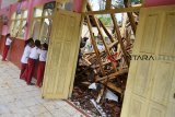 Siswa Sekolah Dasar Negeri Kertajaya melihat kelasnya yang ambruk di Desa Kawitan, Kabupaten Tasikmalaya, Jawa Barat, Selasa (13/11/2018). Akibat diguyur hujan deras disertai agin kencang membuat satu ruang kelas ambruk, sehingga jika terjadi hujan deras kegiatan belajar mengajar dihentikan karena takut terjadi ambruk susulan dan berharap kepada pemerintah setempat segera diperbaiki. ANTARA JABAR/Adeng Bustomi/agr.