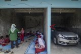 Murid SDN Dayeuhkolot 7 melaksanakan Ujian Akhir Sekolah (UAS) di garasi mobil di Dayeuhkolot, Kabupaten Bandung, Jawa Barat, Jumat (30/11/2018). Murid SDN Dayeuhkolot 7 terpaksa melakukan UAS di garasi mobil akibat sekolahnya terendam banjir luapan Sungai Citarum. ANTARA JABAR/Raisan Al Farisi/agr.