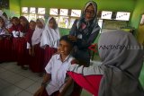 Petugas medis memberikan suntikan imunisasi Measles Rubella (MR) di SDN Kertajaya, Salopa, Kabupaten Tasikmalaya, Jawa Barat, Selasa (13/11/2018). Kemenkes menargetkan pencapaian program imunisasi MR untuk 70 juta anak menjadi 85 persen, dari target awal 95 persen. ANTARA JABAR/Adeng Bustomi/agr.