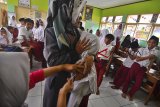 Petugas medis memberikan suntikan imunisasi Measles Rubella (MR) di SDN Kertajaya, Salopa, Kabupaten Tasikmalaya, Jawa Barat, Selasa (13/11/2018). Kemenkes menargetkan pencapaian program imunisasi MR untuk 70 juta anak menjadi 85 persen, dari target awal 95 persen. ANTARA JABAR/Adeng Bustomi/agr.