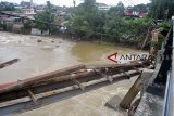 Suasana tiang penyangga jembatan Sarijan yang ambruk di Kota Bogor, Jawa Barat, Senin (12/11/2018). Hujan deras yang mengguyur Kota Bogor sejak Sabtu (10/11/2018) mengakibatkan debit air sungai Cisadane naik mencapai 175 cm dan mengakibatkan ambruknya tiang penyangga jembatan tersebut. ANTARA JABAR/Arif Firmansyah/agr.
