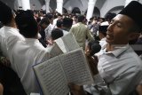 Sejumlah jamaah membaca sholawat nabi saat tradisi berebut koin di masjid Jami Jamsaren, Kota Kediri, Jawa Timur, Senin (19/11/2018) malam. Tradisi pembacaan sholawat nabi yang disertai dengan melempar uang logam tersebut guna memperingati Maulid Nabi Muhammad SAW sekaligus sebagai sarana syiar agama Islam. Antara Jatim/Prasetia Fauzani/ZK