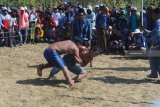 Peserta 'okol' atau gulat tradisional Madura berusaha saling membanting di Desa Nyalabu Daya, Pamekasan, Jawa Timur, Minggu (4/11/2018). Okol yang dilaksanakan hanya saat musim kemarau panjang itu dimaksudkan untuk meminta hujan kepada Yang Maha Kuasa. Antara Jatim/Saiful Bahri/ZK