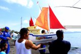 Warga membawa sesaji dalam kapal kecil yang akan dilarung di Laut Pantai Waru Doyong, Banyuwangi, Jawa Timur, Rabu (7/11/2018). Pada hari Rabu wekasan (hari Rabu terakhir di bulan Safar) ini, diperingati oleh warga pesisir dengan tradisi doa dan petik laut, sebagai tolak bala. Antara Jatim/Budi Candra Setya/ZK.