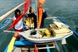 Warga membawa sesaji dalam kapal kecil yang akan dilarung di Laut Pantai Waru Doyong, Banyuwangi, Jawa Timur, Rabu (7/11/2018). Pada hari Rabu wekasan (hari Rabu terakhir di bulan Safar) ini, diperingati oleh warga pesisir dengan tradisi doa dan petik laut, sebagai tolak bala. Antara Jatim/Budi Candra Setya/ZK.